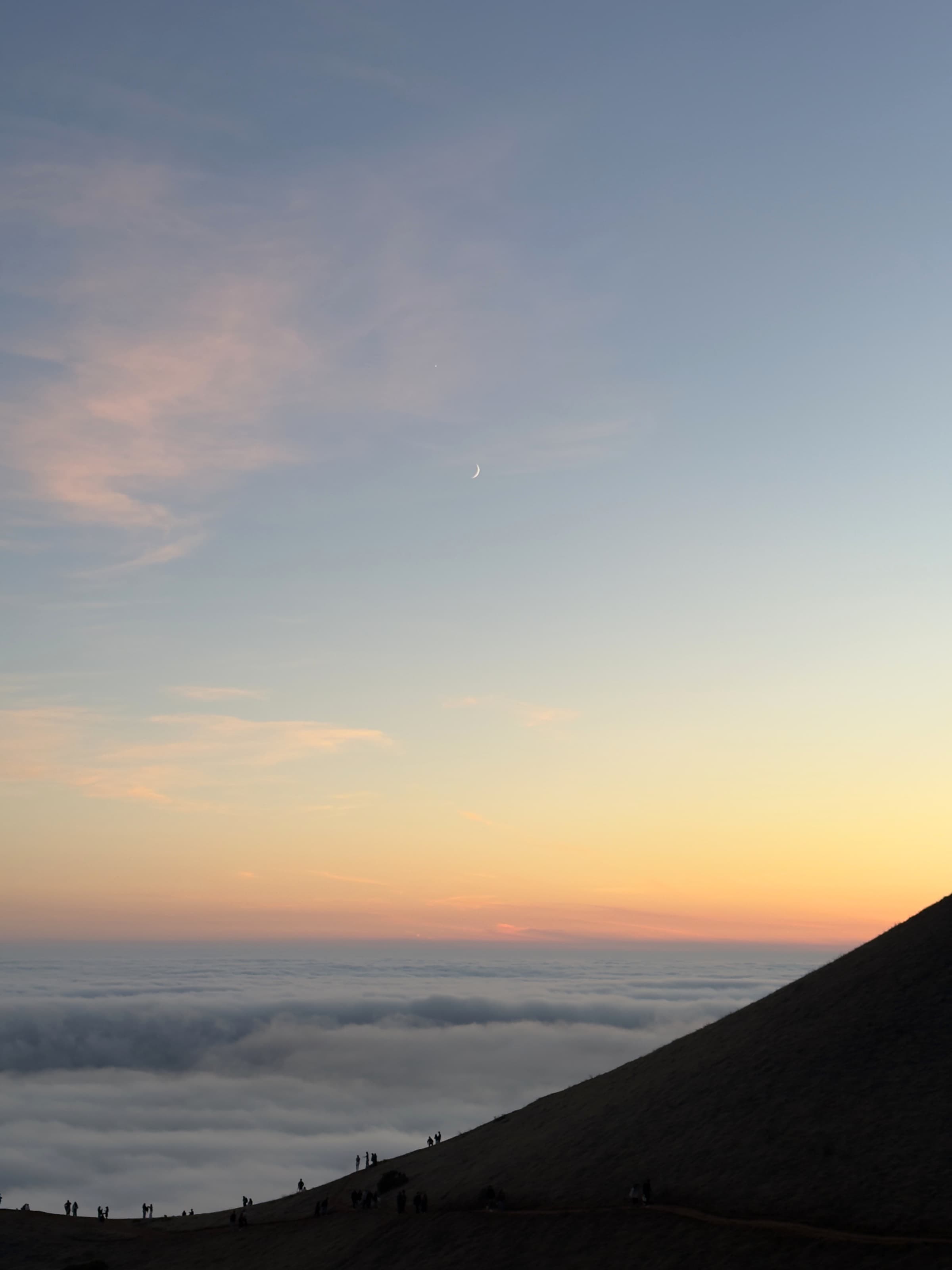 A crescent moon above the marine layer at Trojan Point.